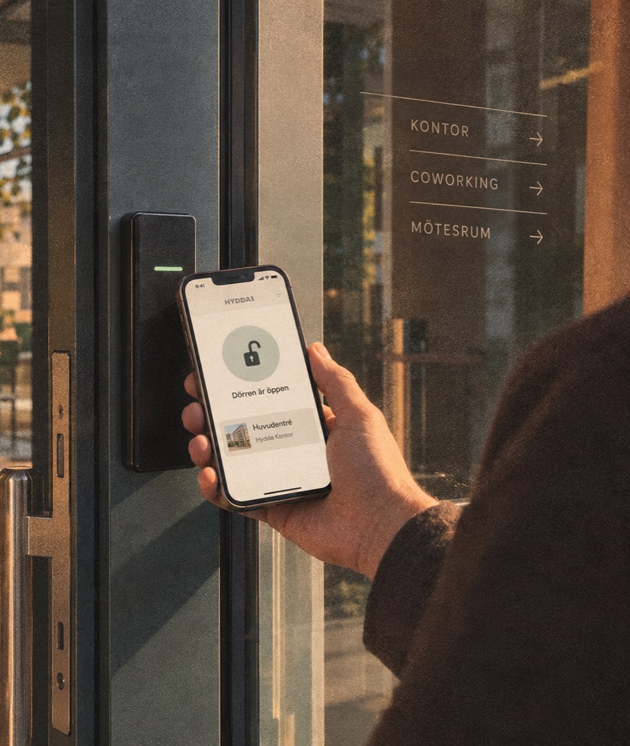 En boende låser upp en entrédörr med mobilen